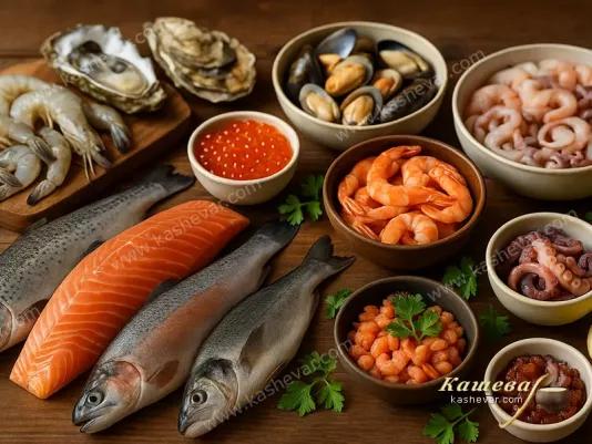 Свежая рыба и разнообразные морепродукты на кухонном столе