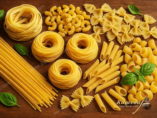Different types of pasta and macaroni on a wooden surface