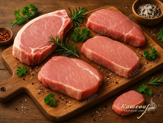 Raw pieces of pork on a cutting board with herbs and spices