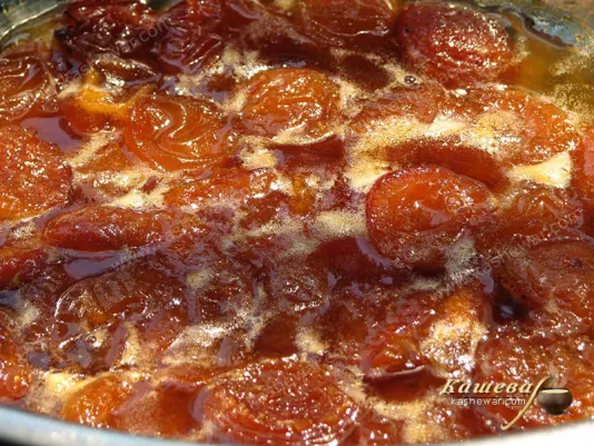 Ready apricot jam with whole apricot halves before pouring into jars