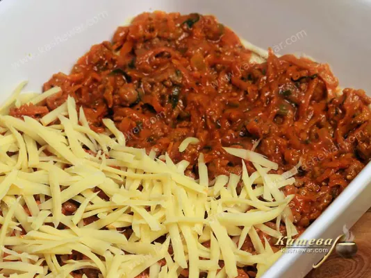 Grated cheese on a layer of Bolognese sauce