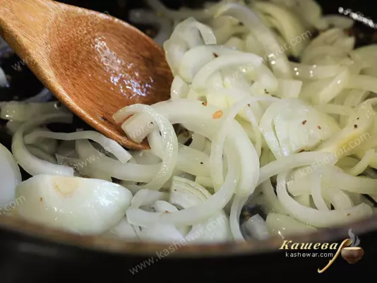 Cut onion in half rings in a frying pan