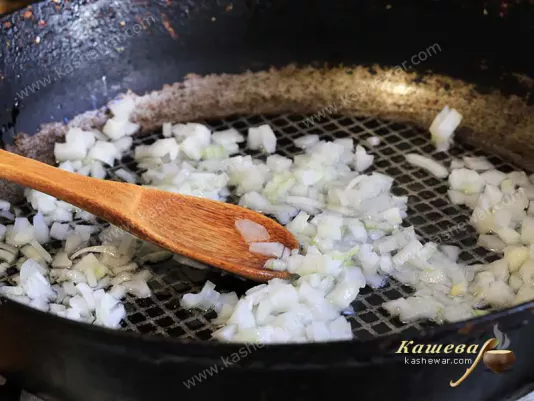 Мелко порезанный лук в сковороде с оливковым маслом
