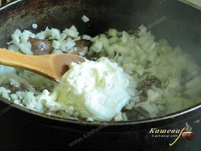 Rabbit, onion and sour cream in a frying pan