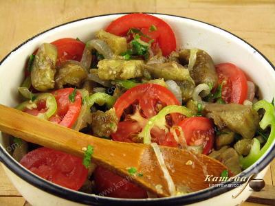 Mixing eggplant and tomato salad ingredients