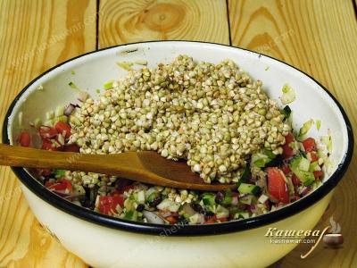 Mixing green buckwheat with the rest of the salad ingredients