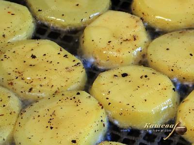 Potatoes with salt and pepper in a frying pan